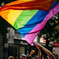 Pride Month in the Philippines: The Joy, the Struggle, and Why June Still Matters Crowd holding rainbow Pride flags during a daytime march.