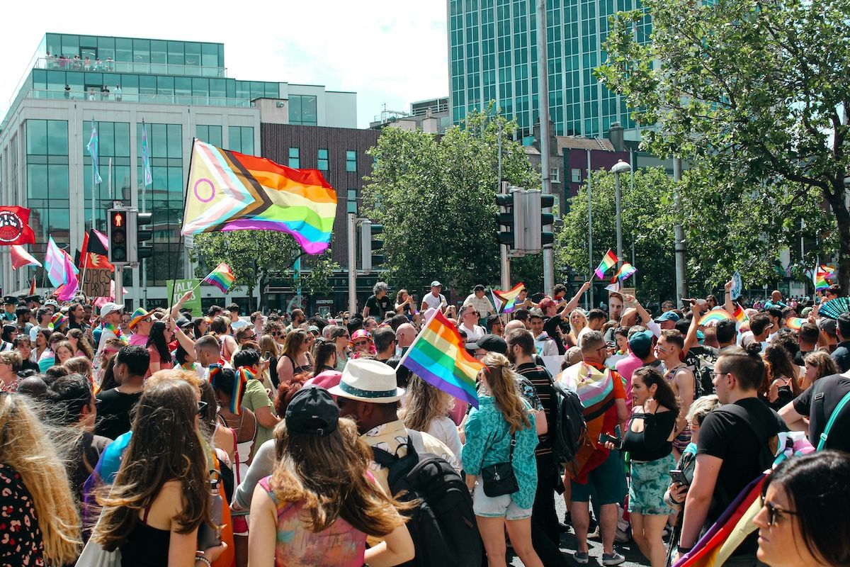 A large group of people walking down a street during a Pride march.